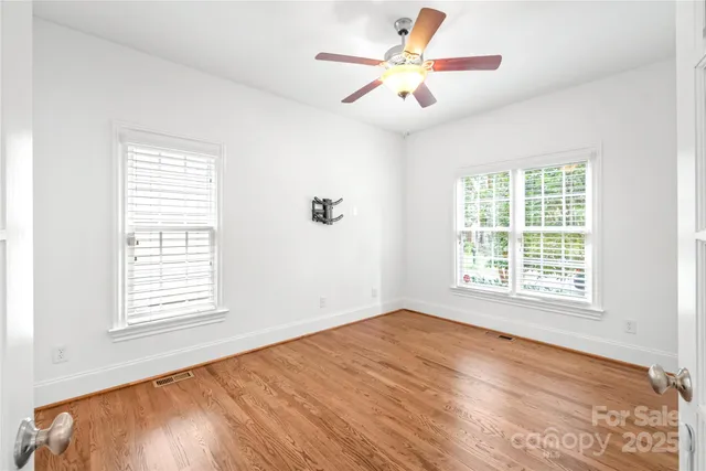 a view of an empty room with a window and a ceiling fan