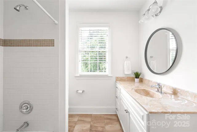 a bathroom with a granite countertop sink a mirror and a bathtub