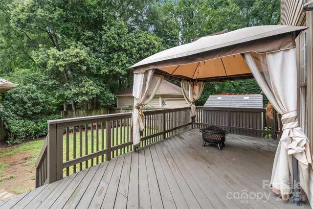 a backyard of a house with wooden floor outdoor seating and yard in the back