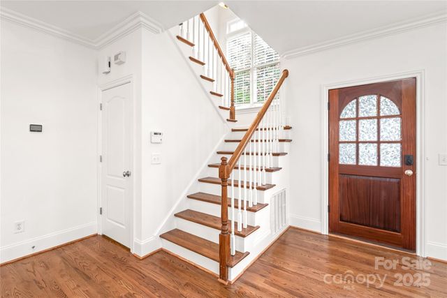 a view of entryway with wooden floor and front door