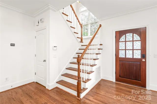 a view of entryway with wooden floor and front door