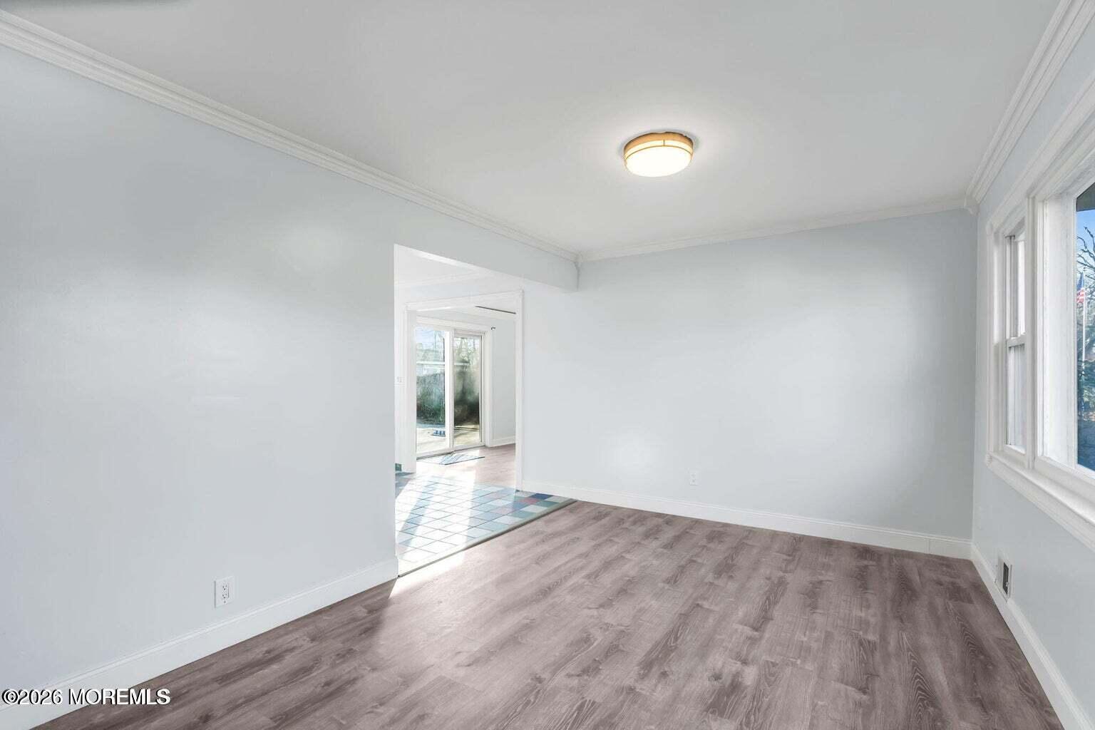 905 Harrison Road Toms River, NJ 08753 - Photo 11 of 34 an empty room with wooden floor and windows