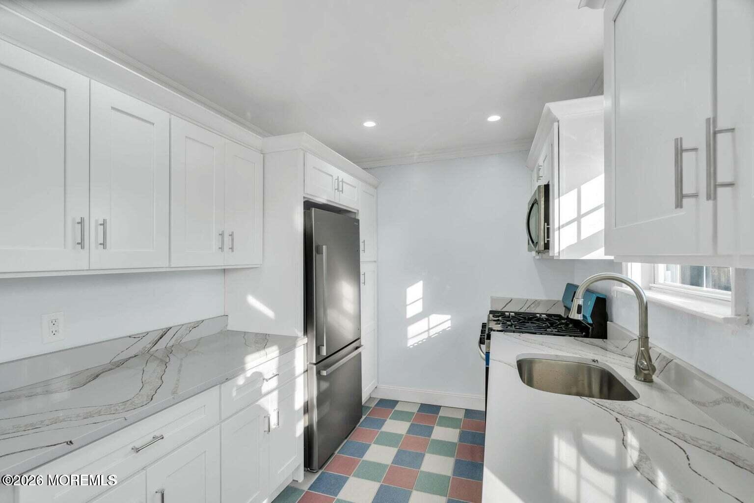 905 Harrison Road Toms River, NJ 08753 - Photo 18 of 34 a kitchen with a sink a refrigerator and cabinets