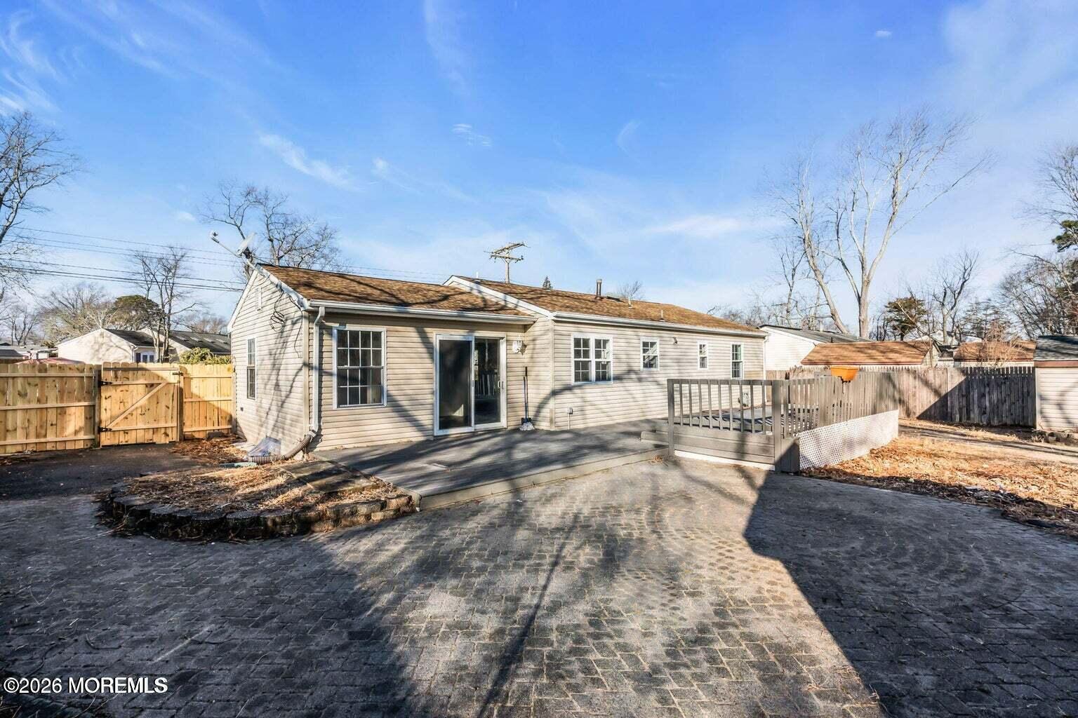 905 Harrison Road Toms River, NJ 08753 - Photo 5 of 34 a view of a white house with large windows and wooden fence