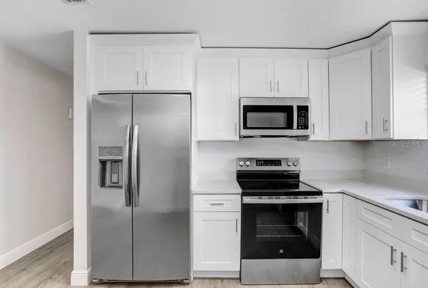 a kitchen with white cabinets and stainless steel appliances