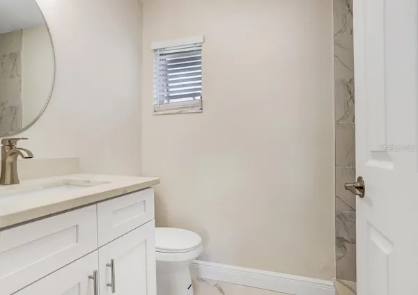 a bathroom with a sink a toilet and a mirror