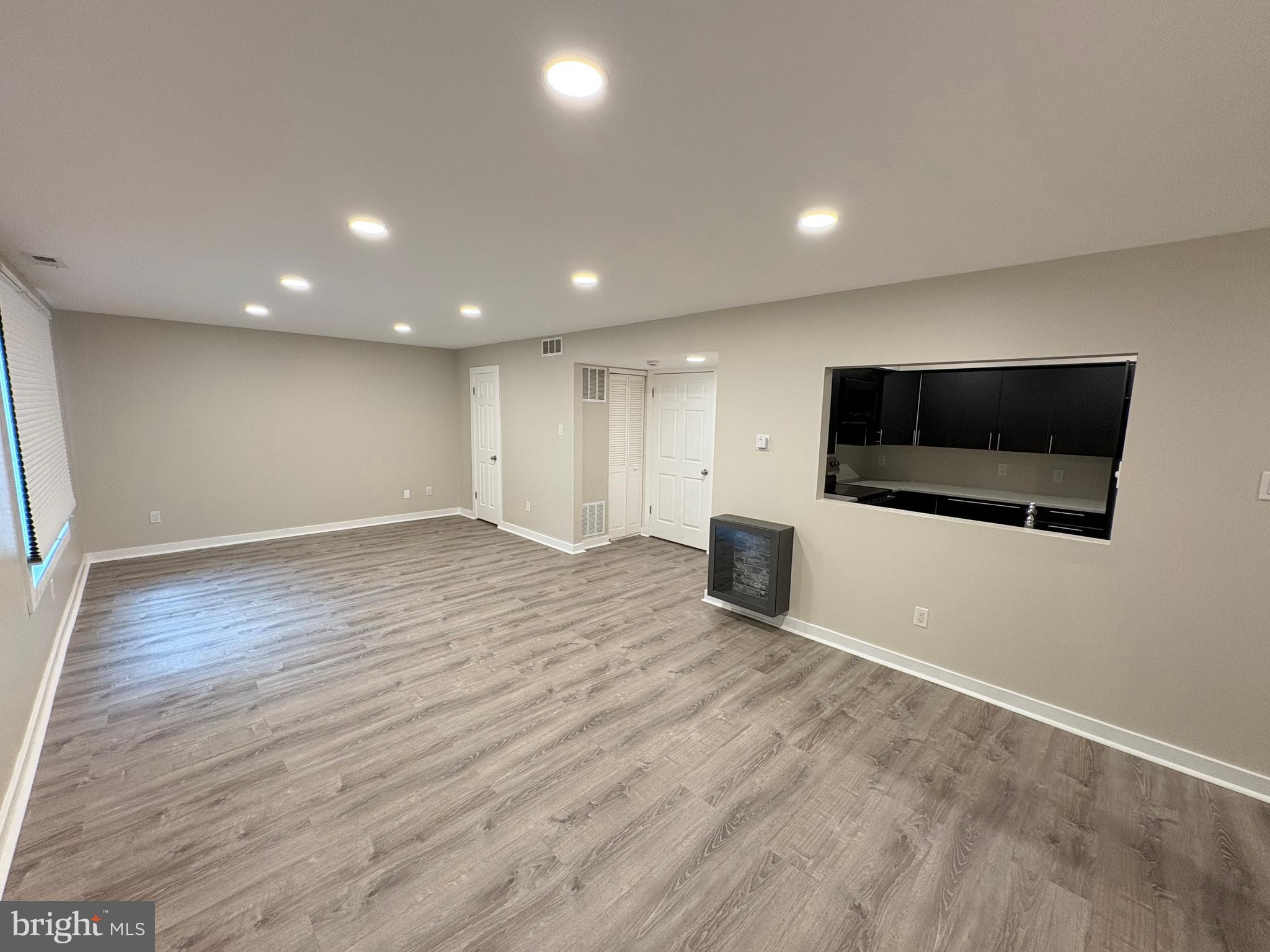 601 Gregorys Way Voorhees, NJ 08043 - Photo 5 of 8 an empty room with wooden floor and kitchen view