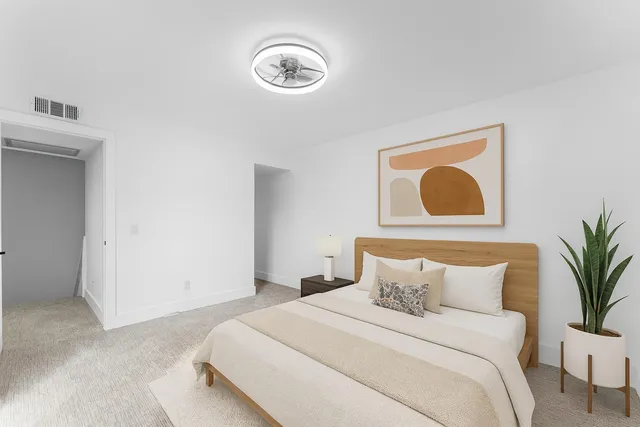 a bedroom with bed and a potted plant