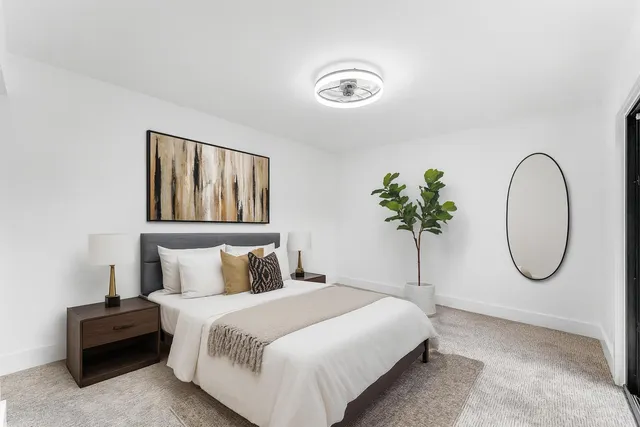 a bedroom with a bed and painting on the wall