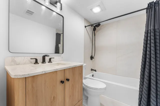 a bathroom with a granite countertop sink toilet and shower