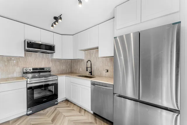 a kitchen with stainless steel appliances a refrigerator sink and microwave