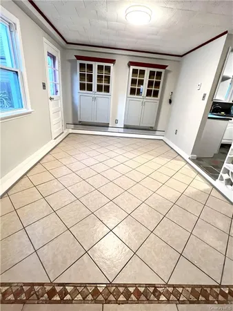 a view of empty room with wooden floor and next to a window