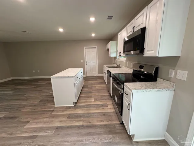 a kitchen with microwave a sink and cabinets