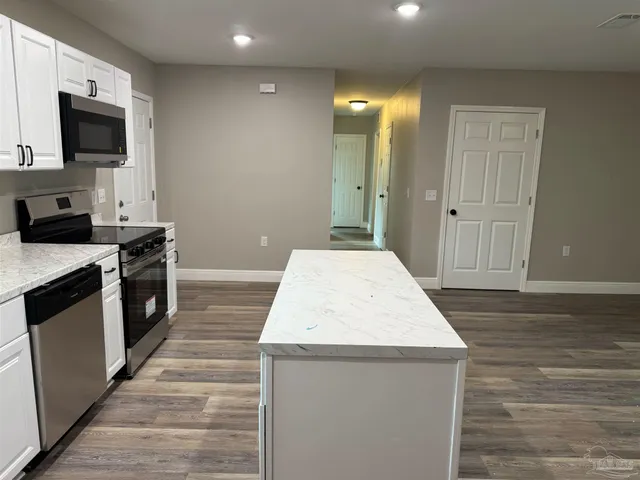 a kitchen with a stove and a wooden floor