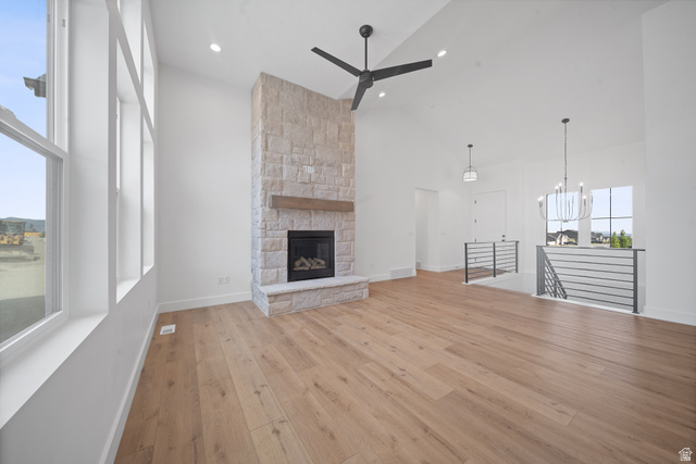 1117 East Shilow Road, Unit 106 Erda, UT 84074 - Photo 1 of 21 Spacious room featuring vaulted ceilings, a prominent stone-clad fireplace with a wood mantel, and large windows