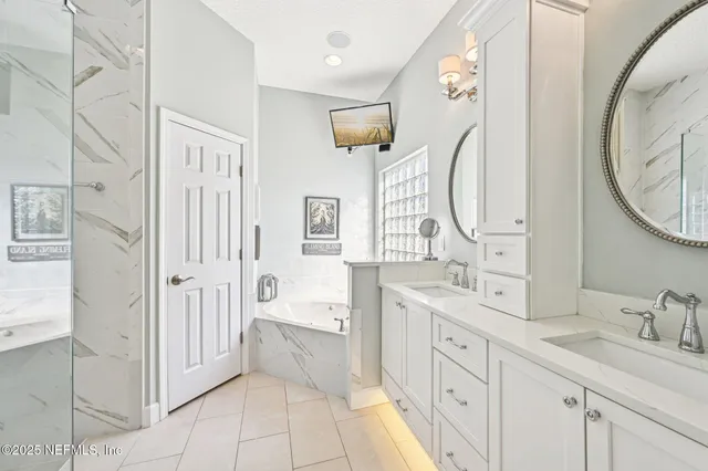 a bathroom with a tub a window and a sink