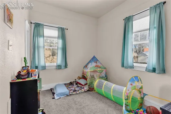 a living room with baby toys and a window