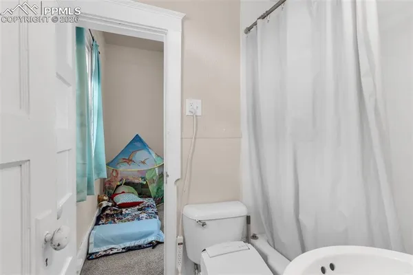 a bathroom with a toilet and a shower curtain