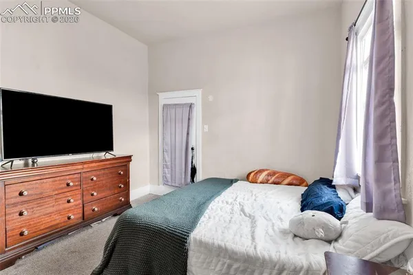 a bedroom with a bed and a flat screen tv