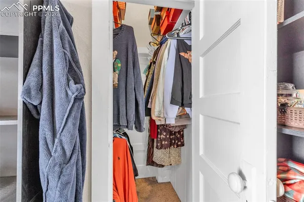 a view of walk in closet with clothes