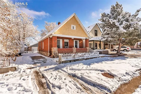 a front view of a house with a yard covered in snow