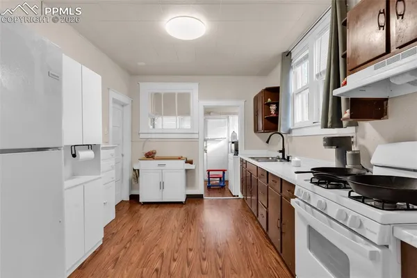 a kitchen with a sink a stove and cabinets