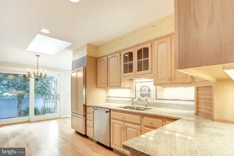 a kitchen with stainless steel appliances granite countertop a sink and a stove