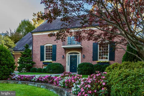 a front view of house and yard with beautiful flowers and green space