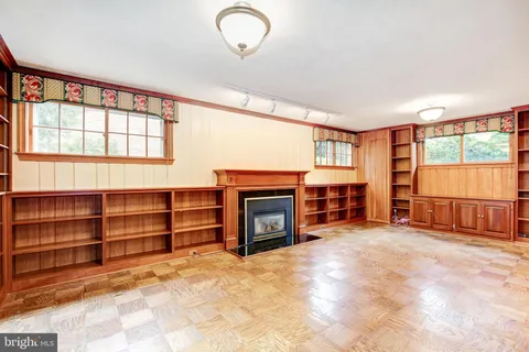 a view of an empty room with a fireplace and a window