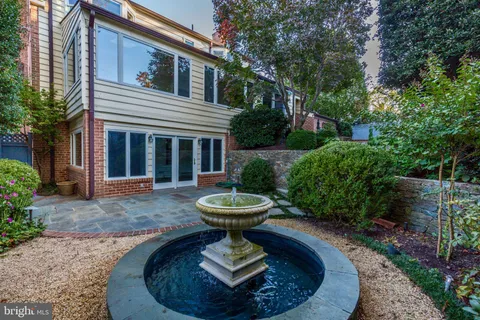 a view of a house with a fountain in a yard