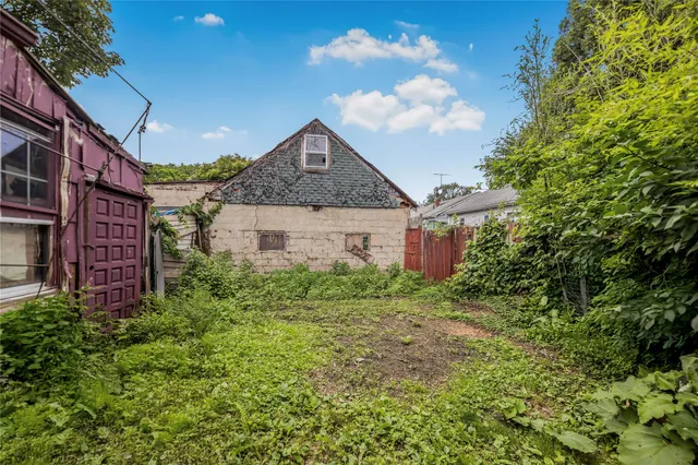 a view of a brick house with a big yard and large trees