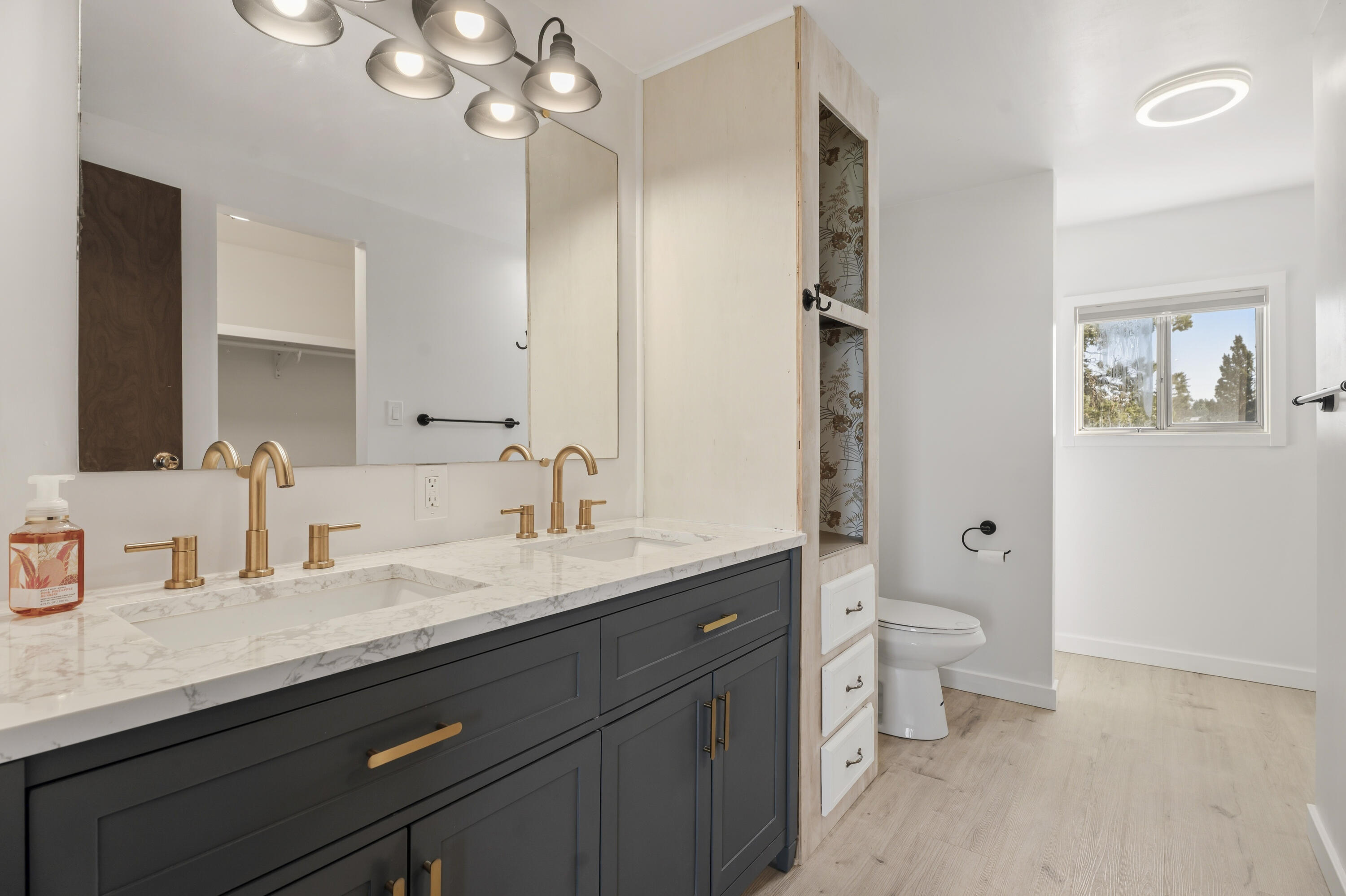 9318 Southwest Panorama Road Terrebonne, OR 97760 - Photo 19 of 45 a bathroom with a granite countertop sink a toilet a large mirror and shower