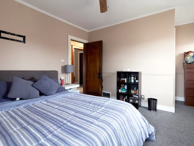 a bedroom with a large bed and a chandelier