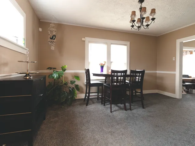 a view of a dining room with furniture and chandelier