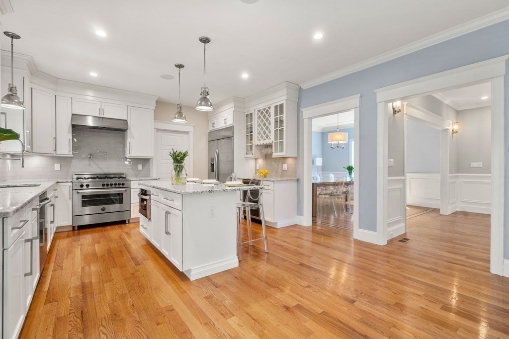 116 School Street Lexington, MA 02421 - Photo 12 of 33 a kitchen with stainless steel appliances kitchen island wooden floors and white cabinets