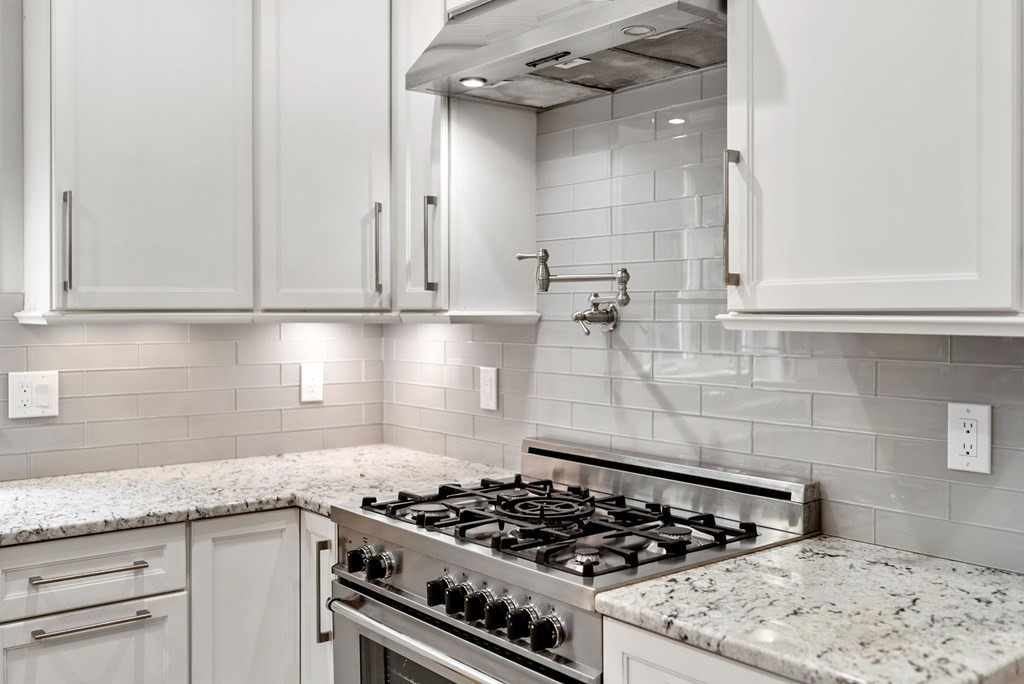 116 School Street Lexington, MA 02421 - Photo 33 of 33 a kitchen with granite countertop a stove and a white cabinets