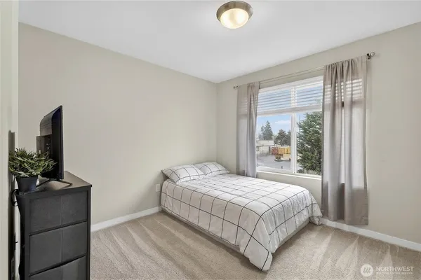 a bedroom with a bed flat screen tv and window
