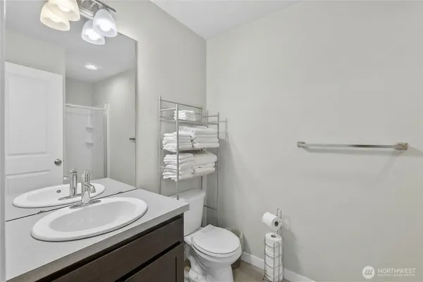 a bathroom with a toilet a sink a mirror and vanity