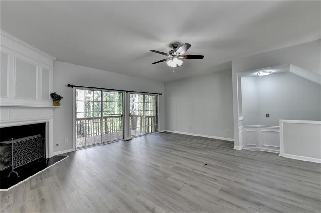 3977 Howell Park Road Duluth, GA 30096 - Photo 10 of 25 a view of an empty room with wooden floor and a fireplace