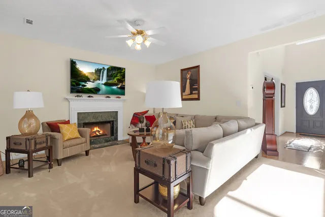 a living room with furniture a flat screen tv and a fireplace