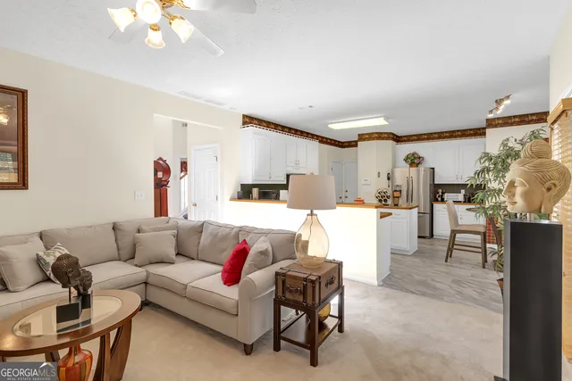 a living room with furniture and kitchen view