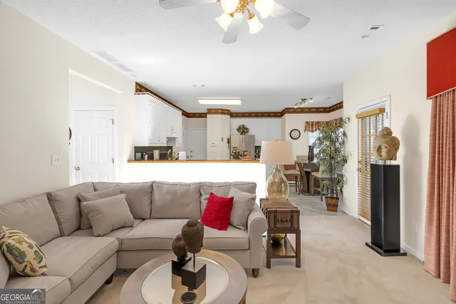 a living room with furniture and kitchen view