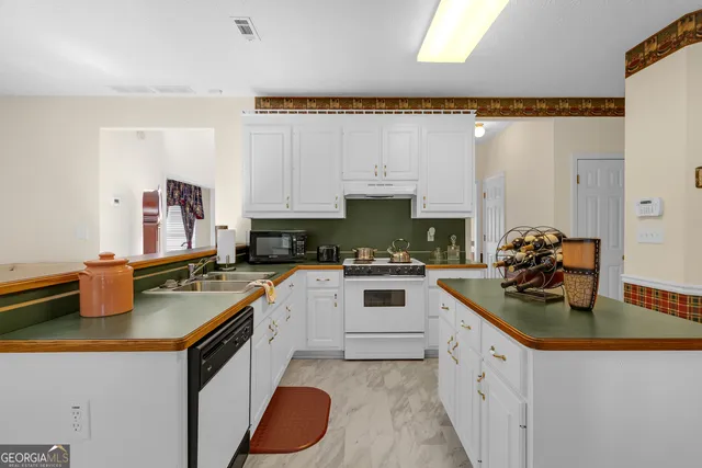 a kitchen with stainless steel appliances granite countertop a sink stove and cabinets