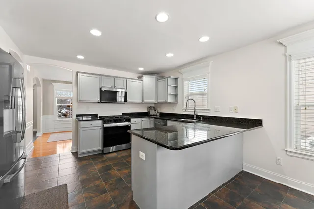 a kitchen with stainless steel appliances granite countertop a sink a stove and a refrigerator