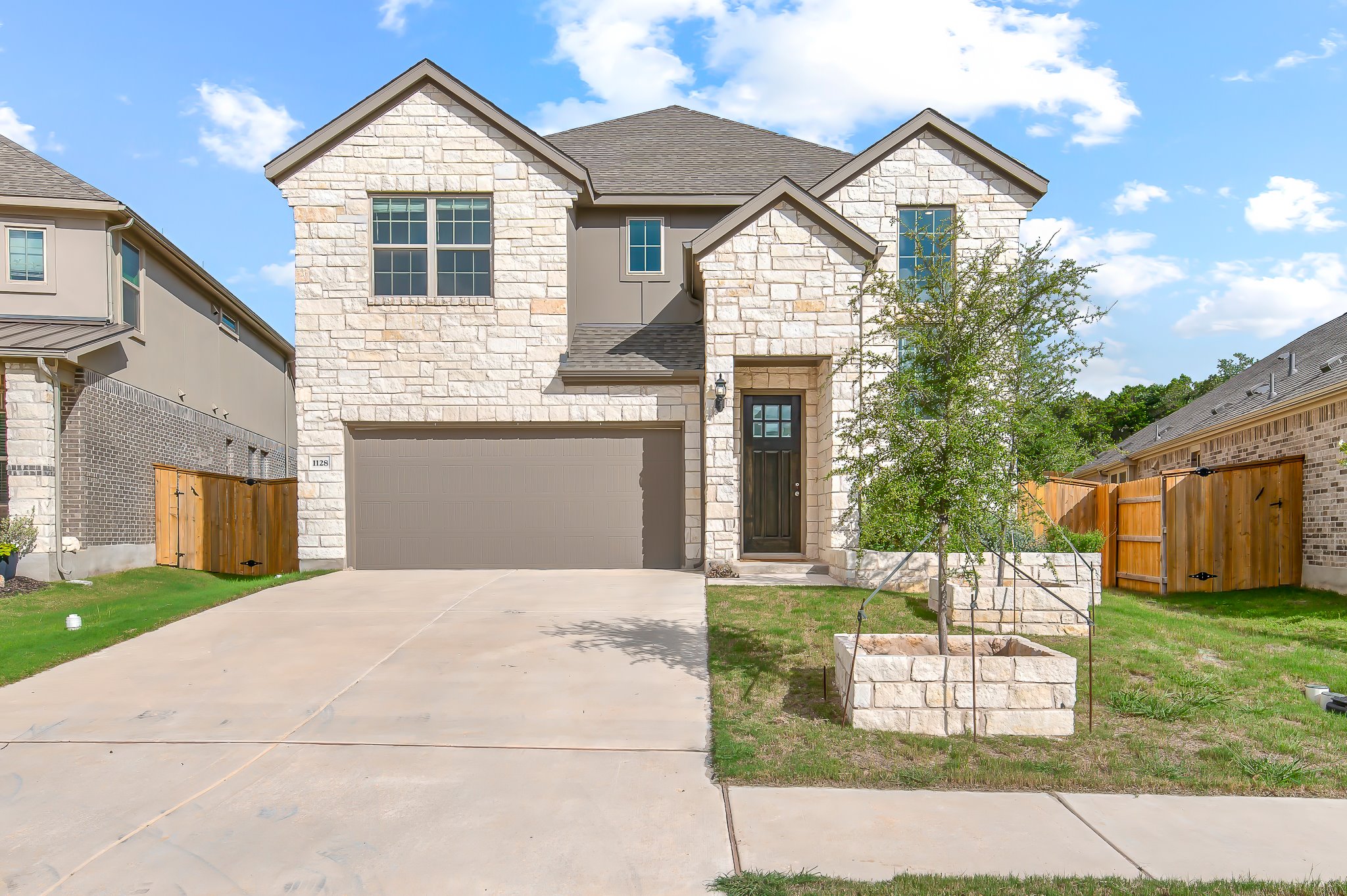 1128 Ridge Runner Drive Georgetown, TX 78628 - Photo 1 of 40 French provincial home with a gate, stone siding, concrete driveway, and a shingled roof