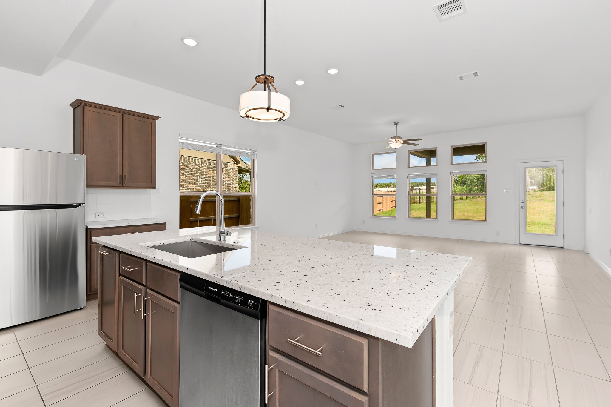 1128 Ridge Runner Drive Georgetown, TX 78628 - Photo 39 of 40 Kitchen with stainless steel appliances, open floor plan, light stone counters, hanging light fixtures, and light tile patterned floors
