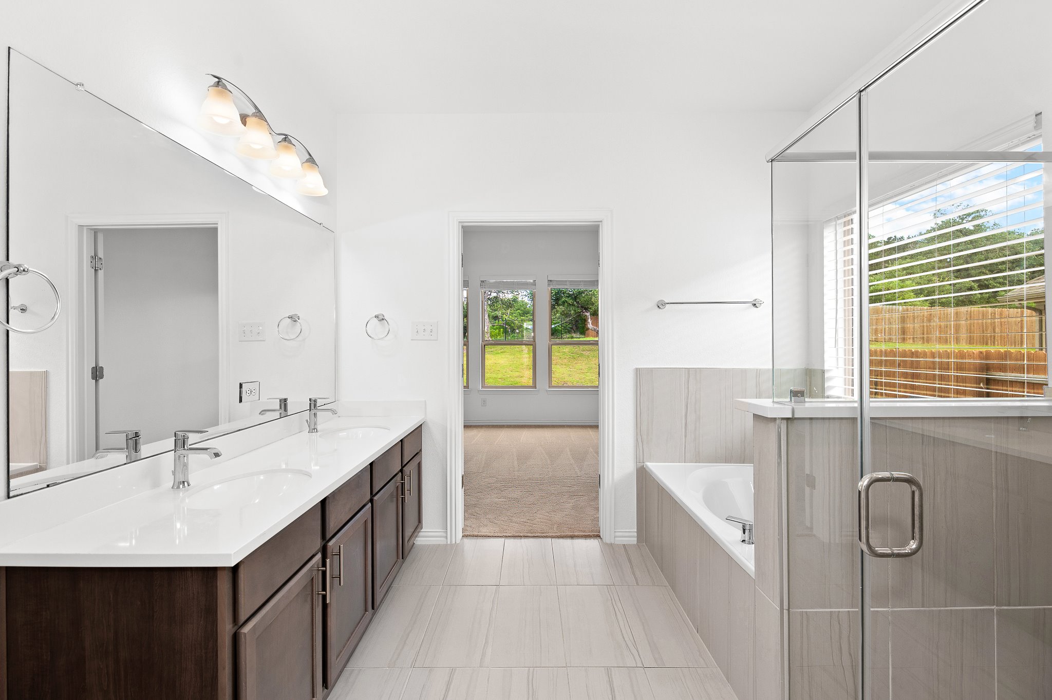 1128 Ridge Runner Drive Georgetown, TX 78628 - Photo 20 of 40 Bathroom featuring double vanity, a stall shower, a garden tub, and light tile patterned flooring