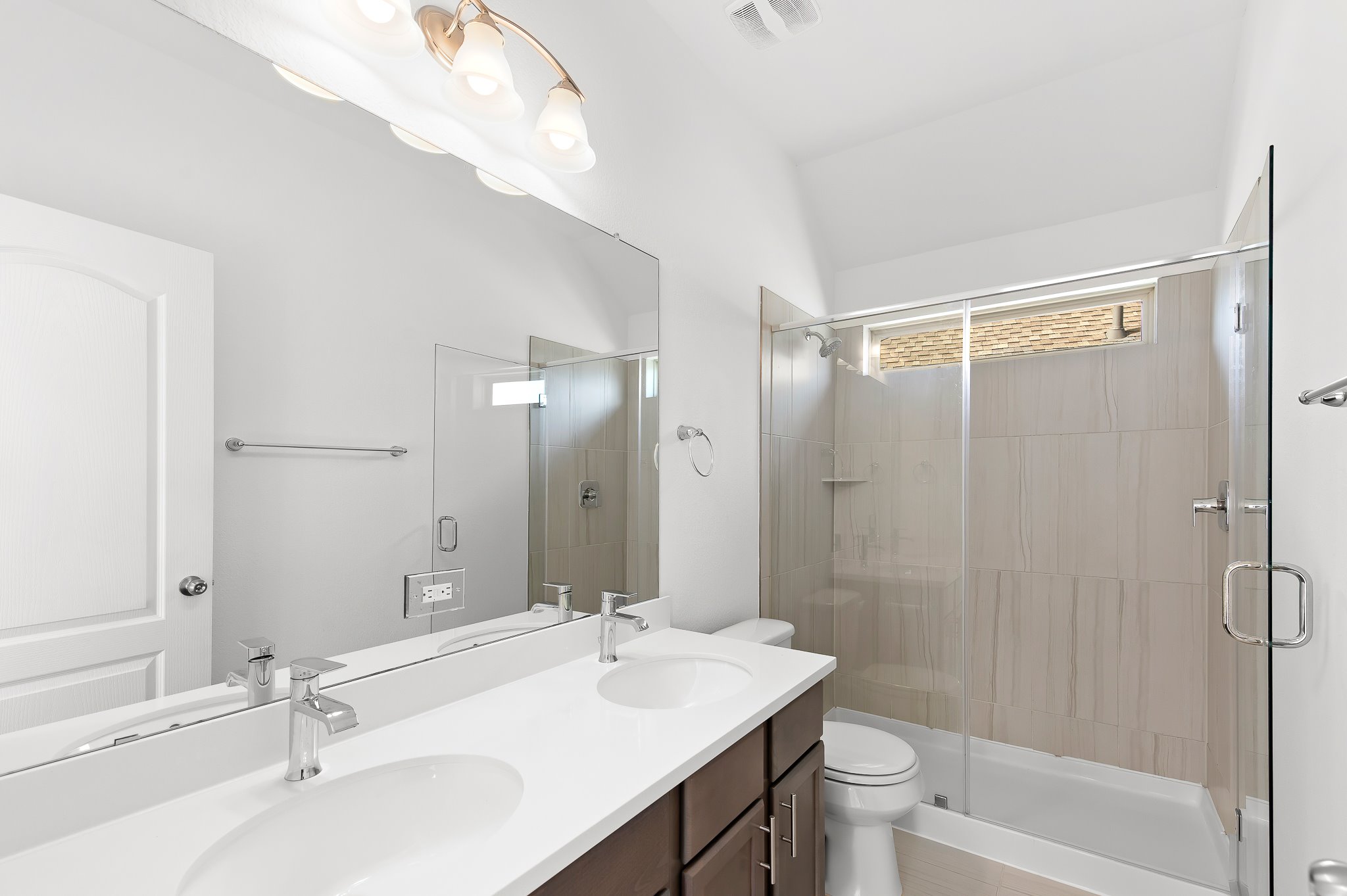 1128 Ridge Runner Drive Georgetown, TX 78628 - Photo 27 of 40 Bathroom with double vanity, a shower stall, and vaulted ceiling