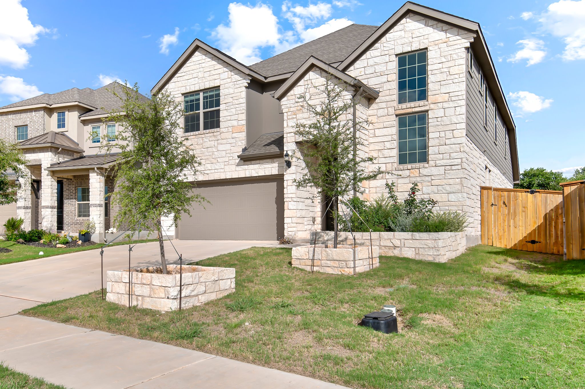 1128 Ridge Runner Drive Georgetown, TX 78628 - Photo 3 of 40 View of front of home with stone siding, a garage, a gate, and driveway