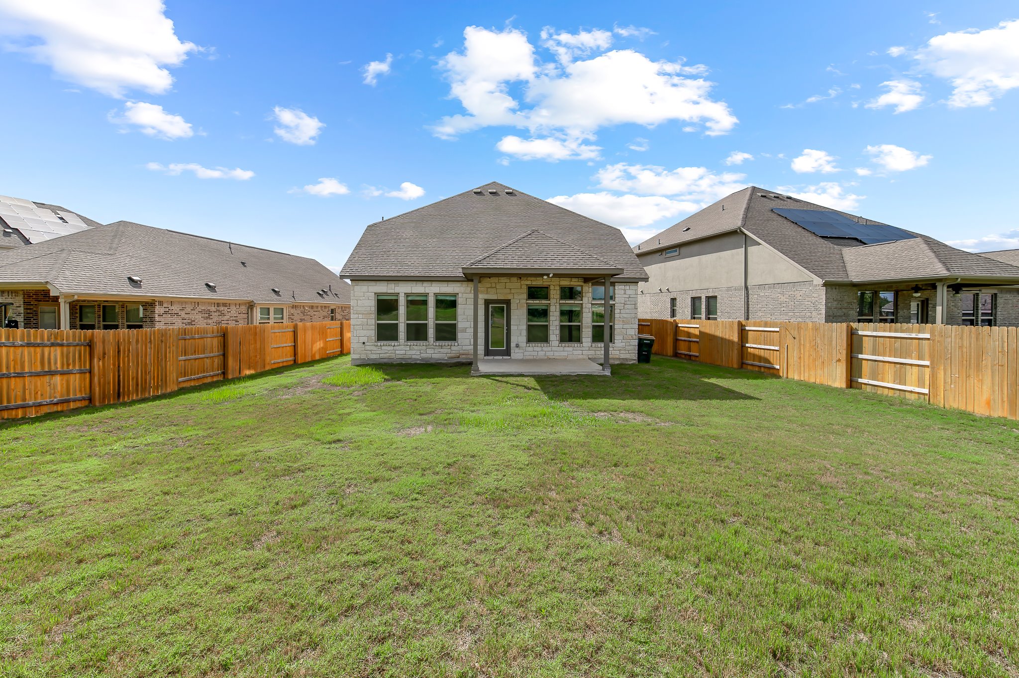 1128 Ridge Runner Drive Georgetown, TX 78628 - Photo 35 of 40 Back of property with a patio area, a fenced backyard, stone siding, and roof with shingles